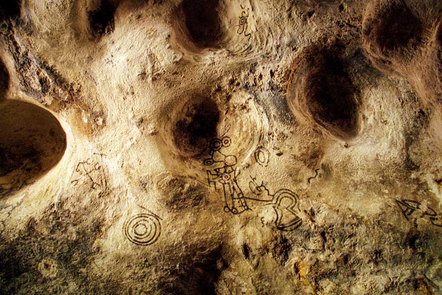 old indian paintings on cave wall