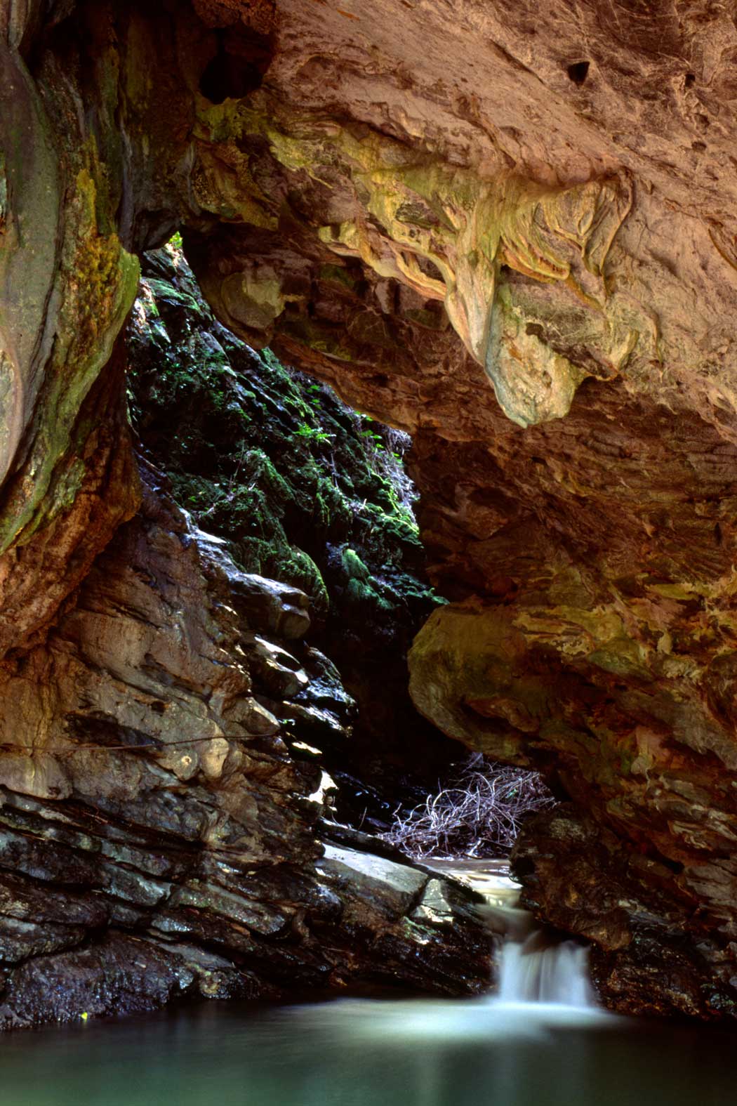 inside a cave with water flowing to a lagoon