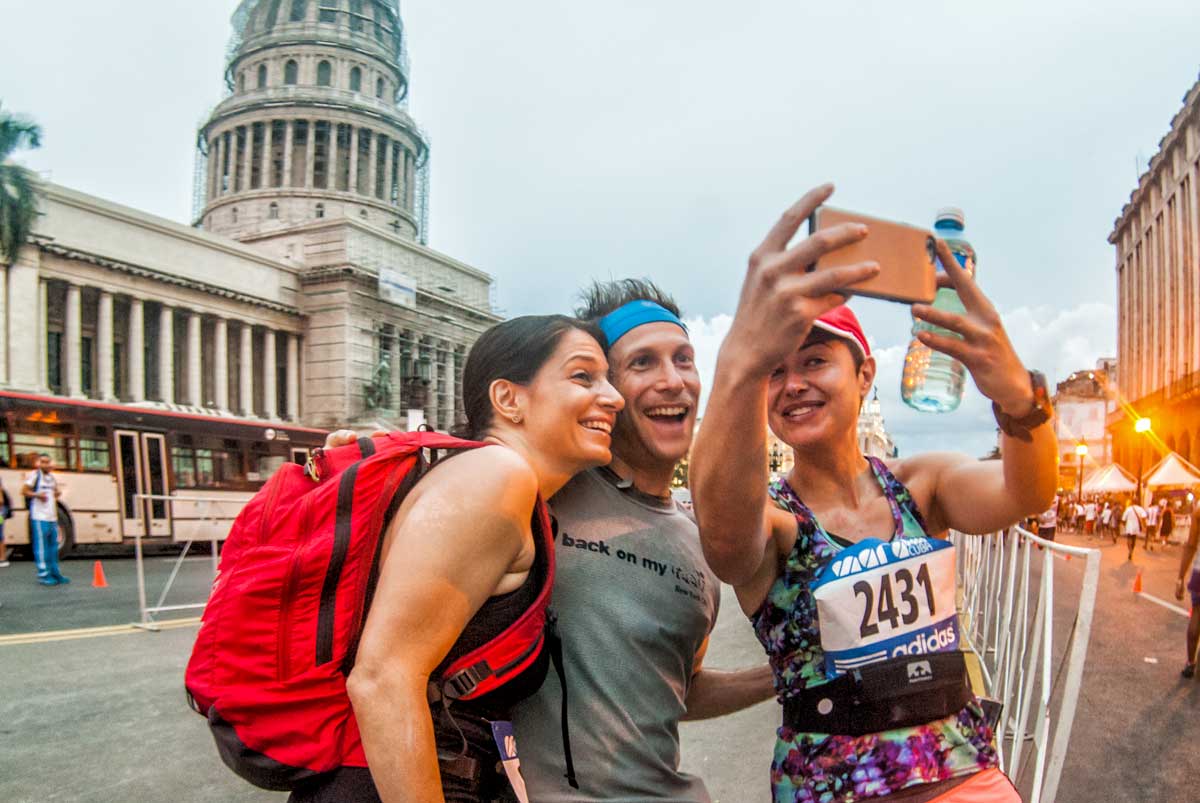three people taking a selfie in front of a parliament building
