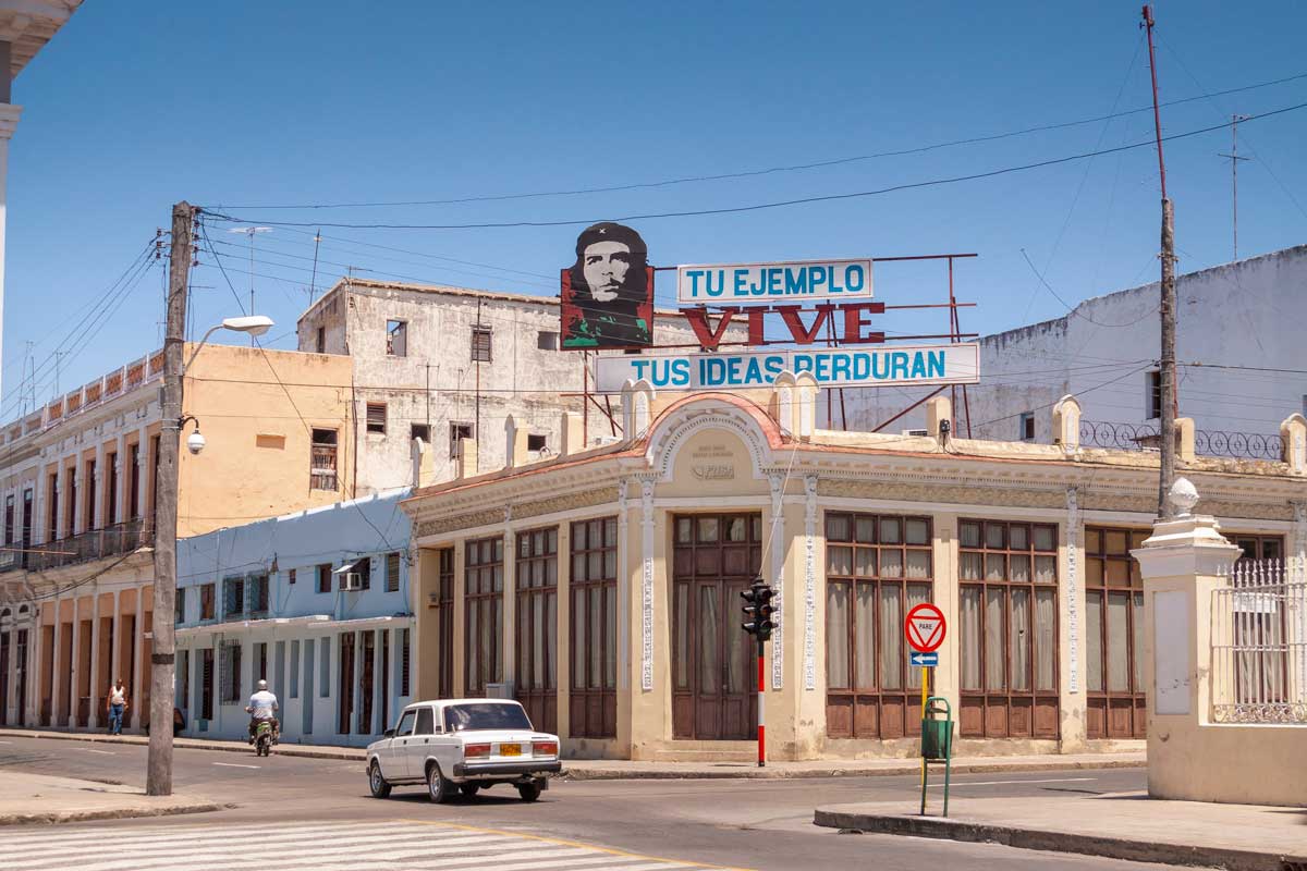 street corner with a car and motorcycle driving by