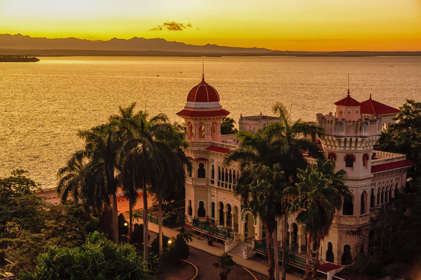 large building in baroque style with palm trees by the ocean